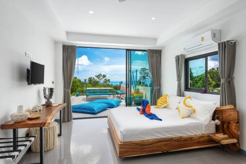 um quarto com uma cama e uma grande janela em Nelumbo Villa - Lamai Seaview - 4 bedroom em Nathon Bay
