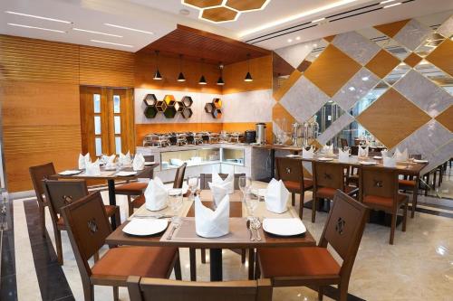 a restaurant with wooden tables and chairs and a kitchen at HOTEL STUDiO23 in Dhaka
