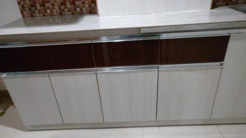 a row of white cabinets in a kitchen at Apartemen Skylounge Makassar in Manda