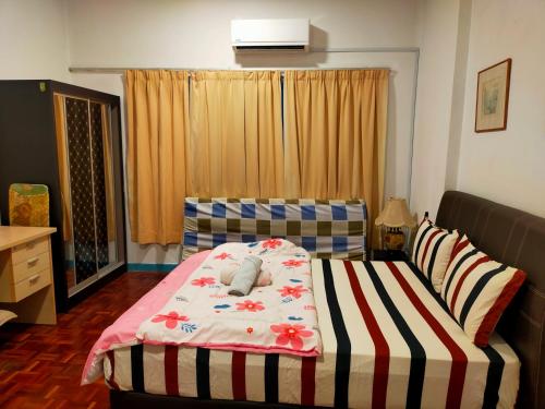 a bedroom with a bed with a striped blanket at R2L5Y Room 1 with balcony and bathroom in Bentong