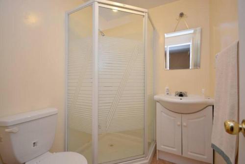 a bathroom with a shower and a toilet and a sink at Riaz's Peaceful Mississauga Home in Mississauga