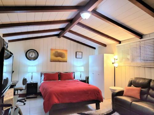 een slaapkamer met een rood bed en een bank bij Guest house-perfect getaway - relaxing space in Temple City