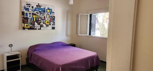 1 dormitorio con cama morada y ventana en PLENO CENTRO Y MUY AMPLIO en Mendoza