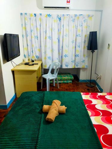 a bedroom with a bed with a desk and a chair at R2L5Y Room 3 with aircond + TV( share Toilet only) in Bentong