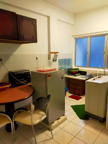 a small kitchen with a table and a refrigerator at R2L5Y Room 3 with aircond + TV( share Toilet only) in Bentong