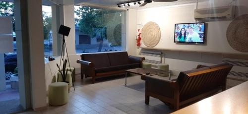 ein Wohnzimmer mit Sofas und einem TV an der Wand in der Unterkunft Hotel Turis in San Rafael