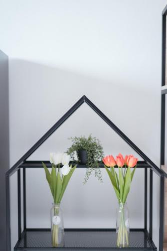 a shelf with two vases with flowers in it at Tulip Hotel in Louang Namtha