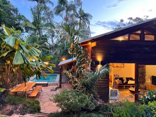 une maison avec une piscine à côté d'un complexe dans l'établissement Beach Jungle - Hot Tub, Firepit & Pool in Beachside Oasis, à Byron Bay