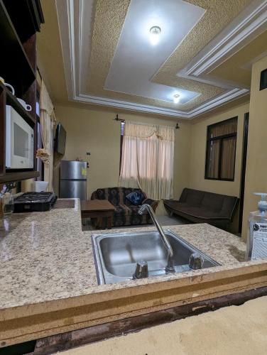 a kitchen with a sink and a living room at Casa González in Santiago Atitlán