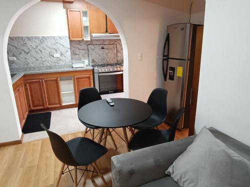 een keuken met een tafel en stoelen in een kamer bij Elegante suite II in Cuenca