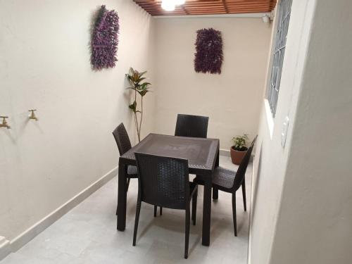 a dining room with a black table and chairs at Elegante suite II in Cuenca