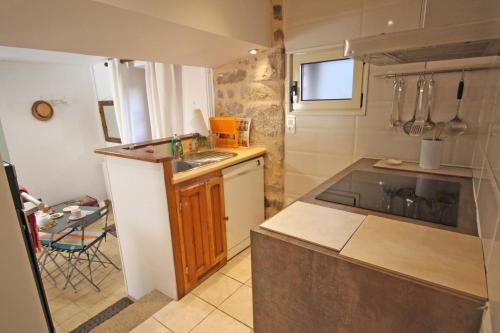 uma pequena cozinha com um lavatório e um fogão em Le gite du sabotier em Ambazac
