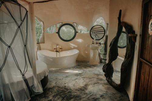 a bathroom with a tub and a sink and a bath tub at Ikalar in Akumal