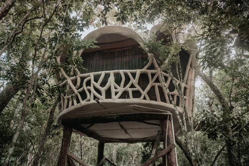 a tree house in the middle of trees at Ikalar in Akumal