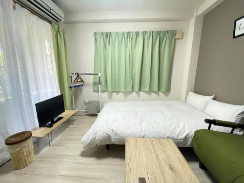 um quarto com uma cama branca e uma cortina verde em マルチステイ大阪京橋32 em Osaka