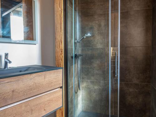 une salle de bain avec une douche avec une porte vitrée dans l'établissement Chalet familial avec jacuzzi, garage et cheminée aux Gets - FR-1-671-245, aux Gets