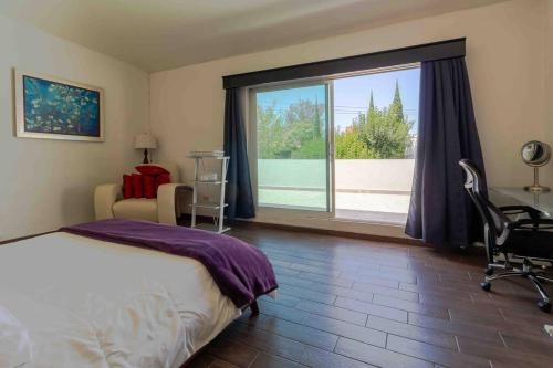 um quarto com uma cama e uma grande janela em Cine-Lux Villa em La Concepción