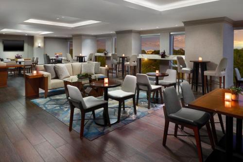 a lobby of a hotel with tables and chairs at Atlanta Airport Marriott Gateway in Atlanta