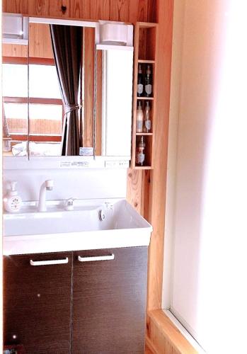 a bathroom with a sink and a mirror and a window at 一棟貸しの宿　松江の里 in Matsue