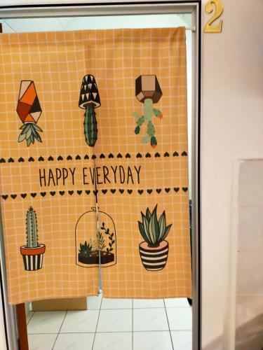 a tiled wall with plants on it with the words happy everyday at R2L5Y Room 2 in Bentong