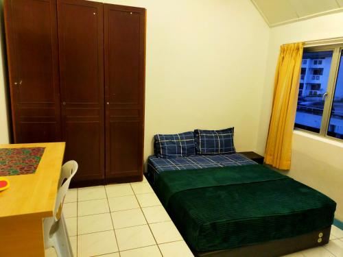 a bedroom with a bed and a table and a window at R2L5Y Room 2 in Bentong