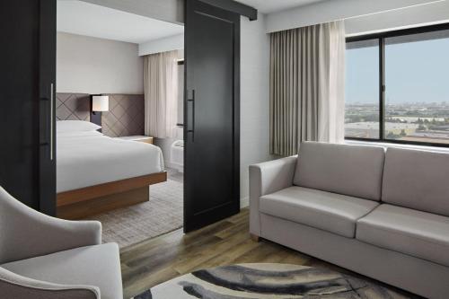 Delta Hotels by Marriott Toronto Markham في ماركهام: غرفه فندقيه بسرير واريكه