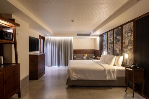 una habitación de hotel con una cama y un televisor en Payaa Hotel, en Pattaya central