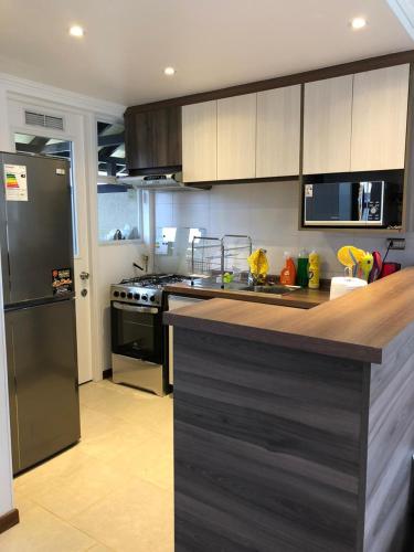 a kitchen with a counter top and a refrigerator at Casa en Condominio in Pucón