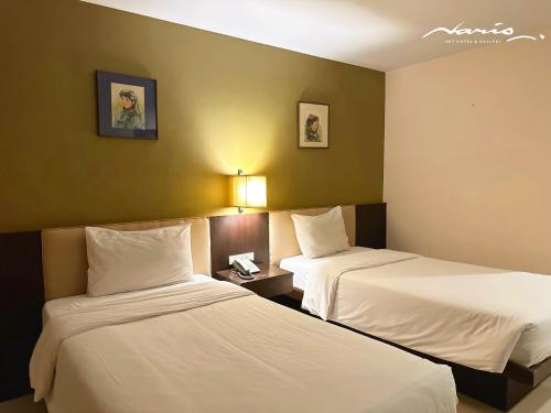 a hotel room with two beds with white sheets at Naris Art Hotel in Pattaya South