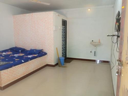 a small bedroom with a bed and a sink at Holiday Tourisms Group of Homestay Food Scuba Diving Boating Watersports-Tarkarli-Devbag Beach in Bhogwe