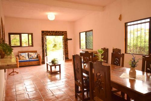 Un comedor con una mesa y sillas y un sofá. en Refugio Campestre en Tepoztlán, en Santo Domingo Ocotitlán