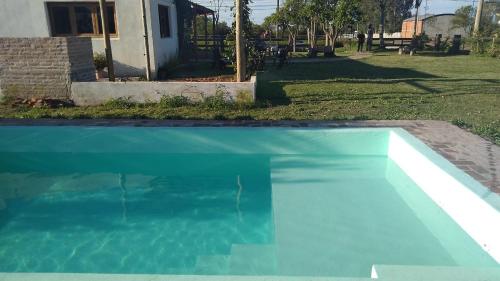 a blue swimming pool in front of a house at Angiru in Mercedes