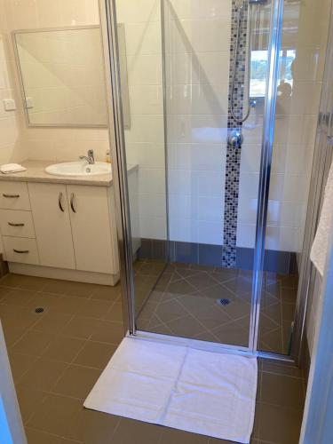 La salle de bains est pourvue d'une douche et d'un lavabo. dans l'établissement The Wooly Guesthouse, à Wagin