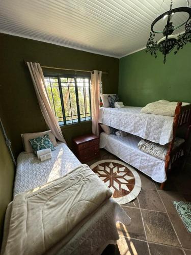 een kamer met 3 bedden en een raam bij Passo dos Bugios in Canela