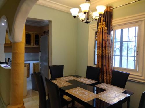 a dining room with a table with chairs and a window at Faith and Grace Guest House in Lamin