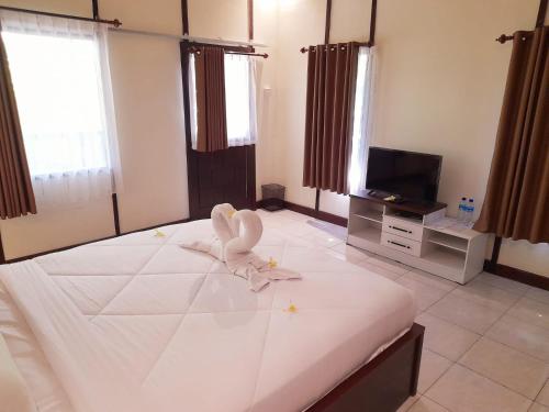 a bedroom with a bed with a towel animal on it at PURI LESTARI in Sorongjukung