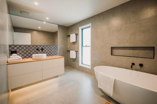 ein Badezimmer mit einer großen Badewanne und einem Waschbecken in der Unterkunft Quail Cove in Gold Coast