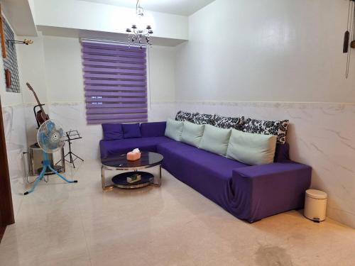 a purple couch in a living room with a table at Berkshire B&B in Qimei