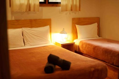 una camera d'albergo con due letti e un telecomando nero di Mt Warning Rainforest Park 