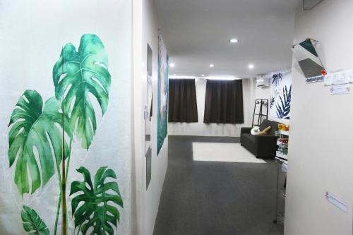 einen Flur mit einem Wohnzimmer mit Pflanzen an der Wand in der Unterkunft Private GameRoom and Cinema at The CEO Penang in Bayan Lepas