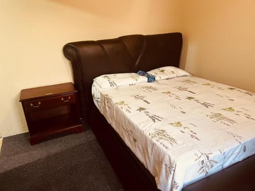 a bed with a black headboard and a night stand at Mphatlalatsane BnB in Maseru