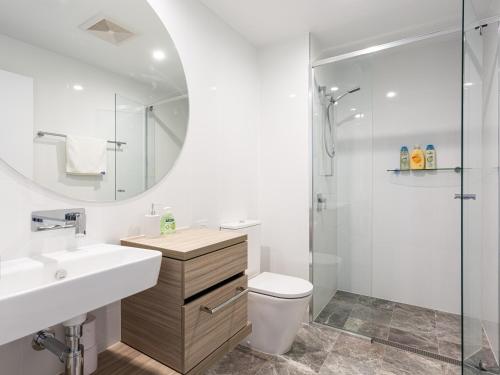 La salle de bains est pourvue d'un lavabo, de toilettes et d'un miroir. dans l'établissement Serain Residences on Qube, à Gold Coast