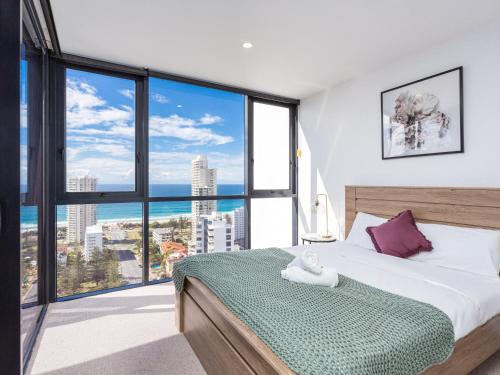 - une chambre avec un lit et une grande fenêtre dans l'établissement Serain Residences on Qube, à Gold Coast