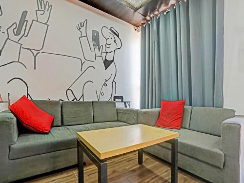 a living room with a couch and a coffee table at Collection O Hotel Shubharambh in Kānpur