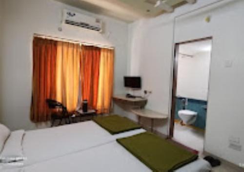 a bedroom with a bed and a desk and a television at Hotel Premier - Hotel in Saket Society Bhusawal in Bhusāwal