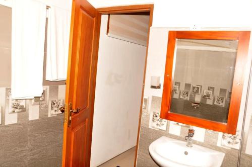een badkamer met een wastafel en een spiegel bij Nature First Hotel in Nuwara Eliya