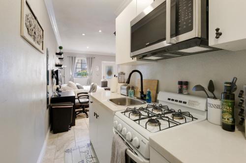 - une cuisine blanche avec cuisinière et évier dans l'établissement Luxury Cozy Studio with Firepit, à Vista