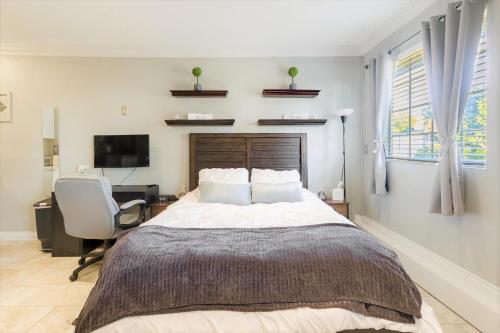 a bedroom with a bed and a desk and a chair at Luxury Cozy Studio with Firepit in Vista