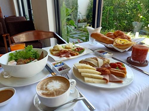 a table with plates of food and a cup of coffee at Nimith Hotel & Restaurant in Phnom Penh