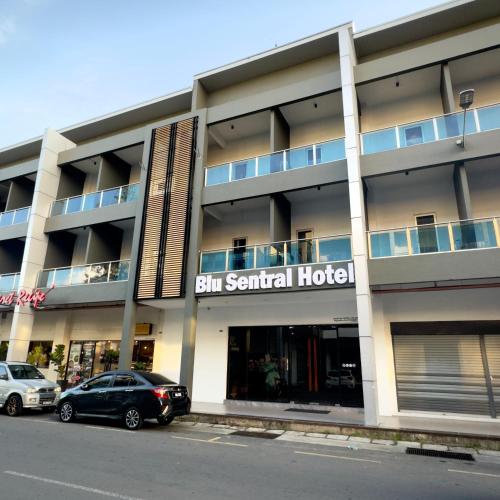 a building with cars parked in front of it at Blu Sentral Hotel in Tawau